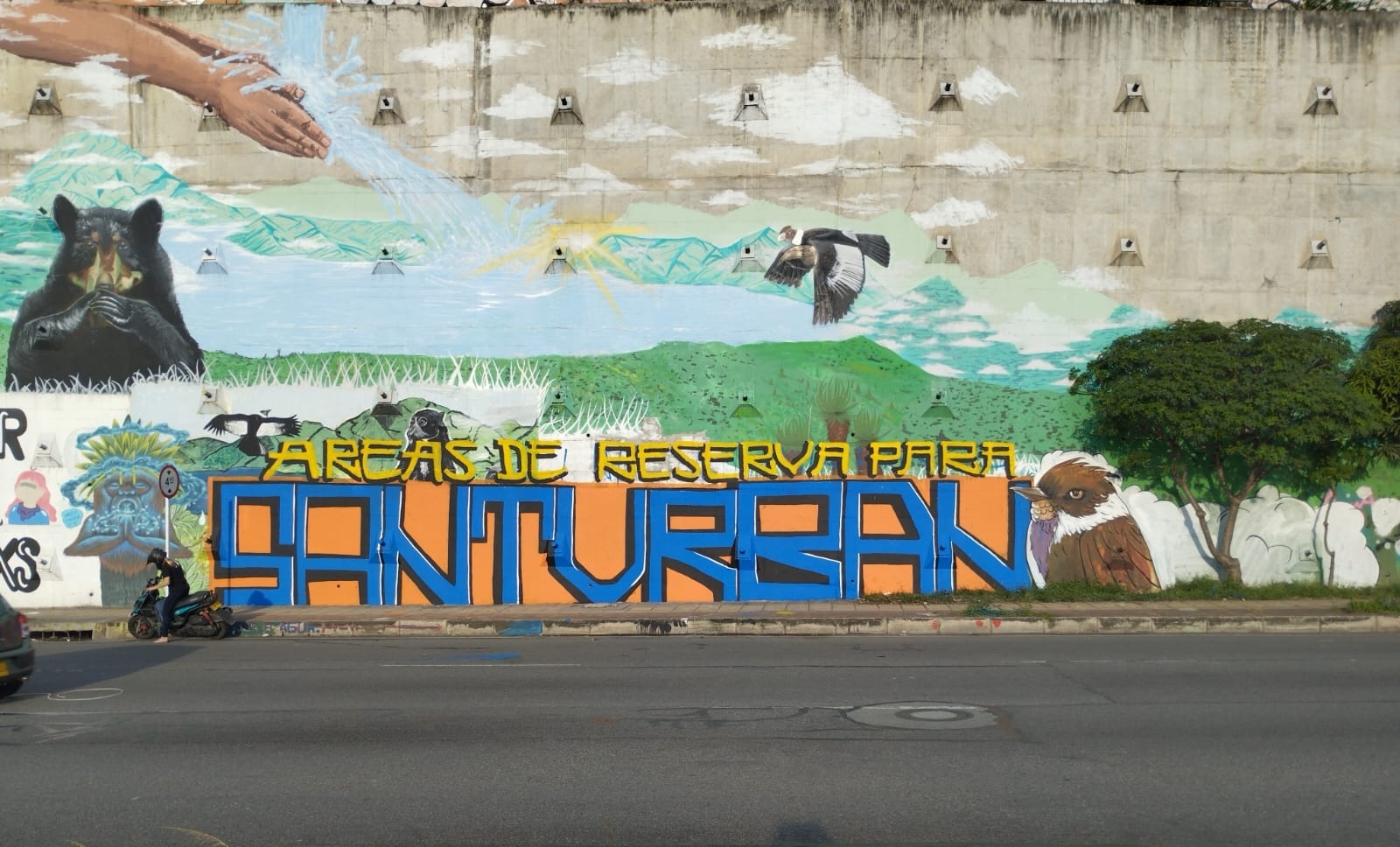 A blue and orange mural shows local Colombian flora and fauna, and the text: Reserve Area for Santurban